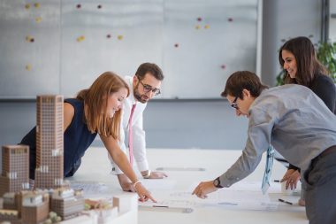 Young office workers in London discussing architectural plans