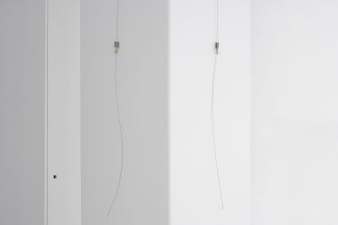 Hanging wires in a white gallery.