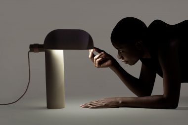 A woman with a contemporary lamp in a London photography studio. Layer Design photo shoot.