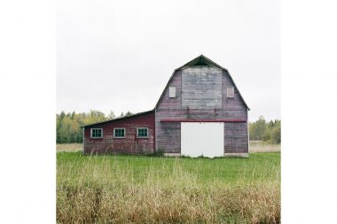 Red and grey barn in field in Minnesota.
