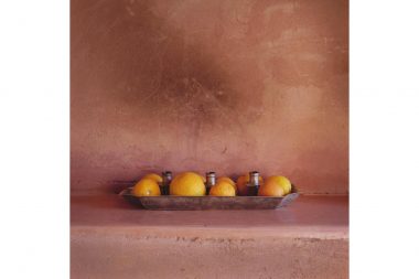 Oranges in a silver candle holder in front of pink plaster walls in Morocco