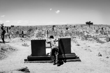 Young boy standing between two graves