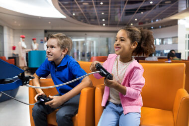 Photograph of kids playing video games while waiting for their flight by Richard Boll