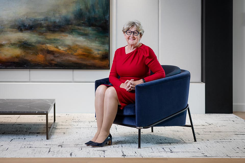 Woman sitting in front of a painting at an investment bank in London