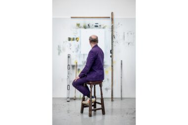 The artist Gavin Turk facing away from the camera in his London studio