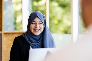 Woman with headscarf talking to colleague