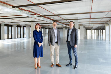 Three people photographed on an empty floor of a corporate building for the Derwent London Annual Report.