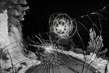 Smashed glass in front of a black and white photograph of a road in Crete.