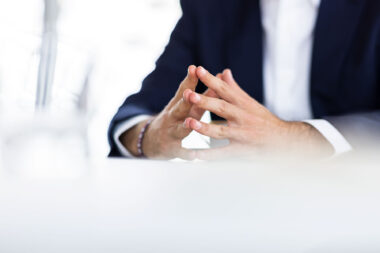 A close-up of a man's hands in a corporate office.