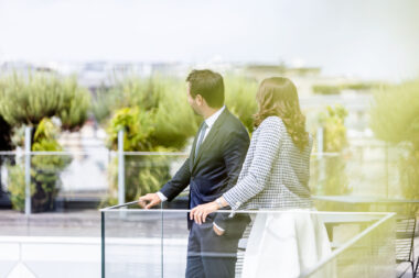 A man and a woman on the roof of a corporate banking building.