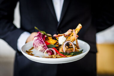 A waiter holding a plate of food at the The OXO Tower Restaurant in London. Marketing photography at its best.
