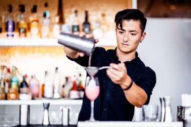 A man pouring a drink with a cocktail shaker at The OXO Tower Restaurant. Marketing photography by Richard Boll.