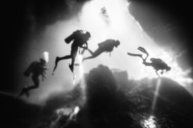 Four divers in an underwater cavern in Crete.