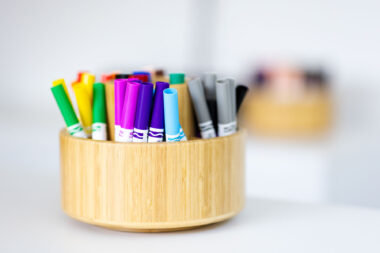 Coloured pens on a desk.