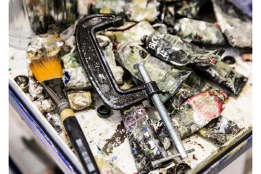 A G clamp and a paintbrush on oil paints in the studio of Gavin Turk.