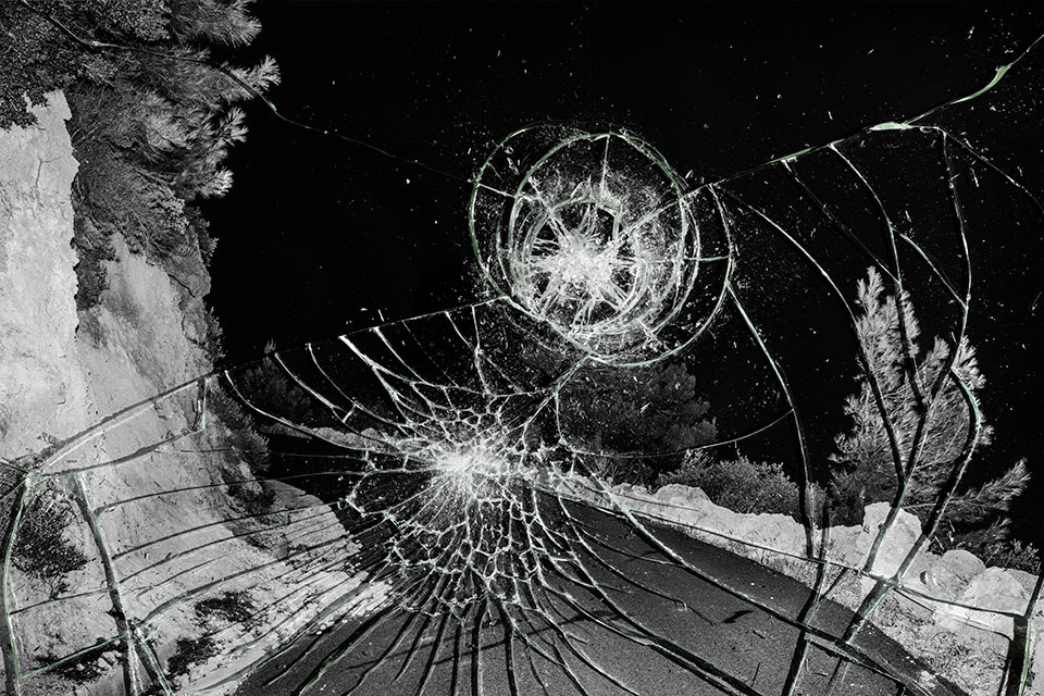 Smashed glass laid over a black and white photograph of a remote road in Crete.