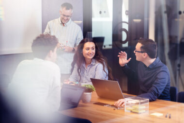 Four people in a corporate meeting photographed for Cavendish Consulting.