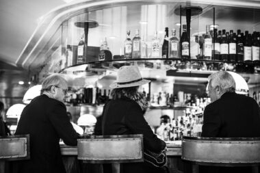 Three people seated at a bar in a luxury venue in London.