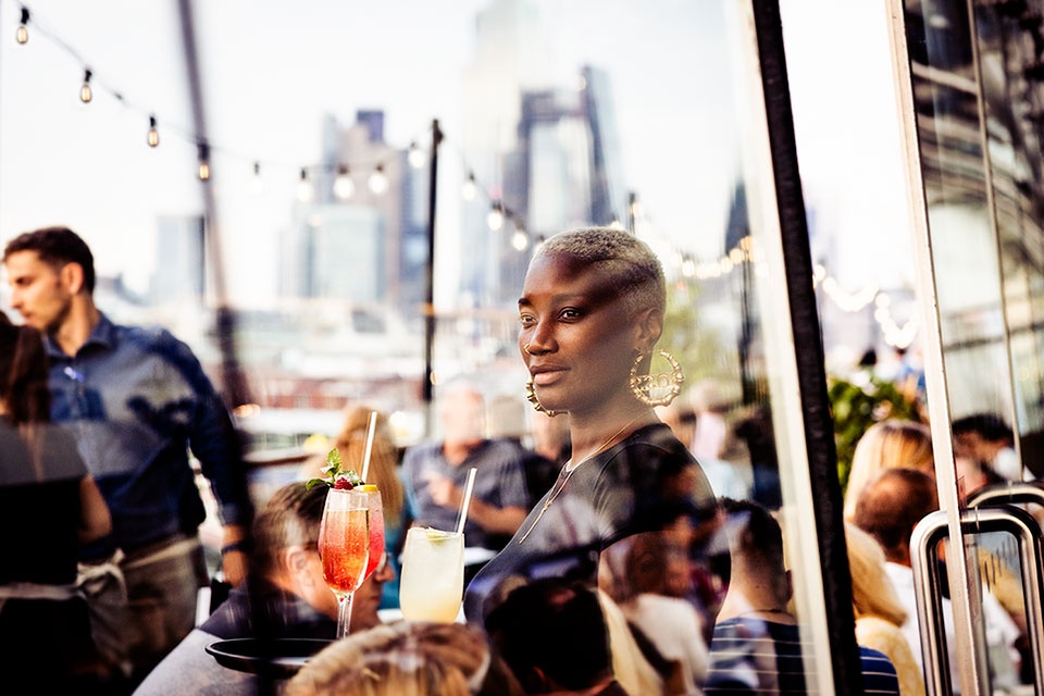 A member of staff at the OXO Tower Restaurant Bar and Brasserie in London with a tray of drinks.