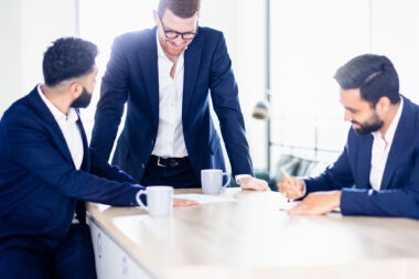 Three men in blue suits in an office in London.