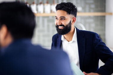 A man smiling in a corporate meeting in London.