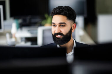 A man working at a computer in a corporate environment.