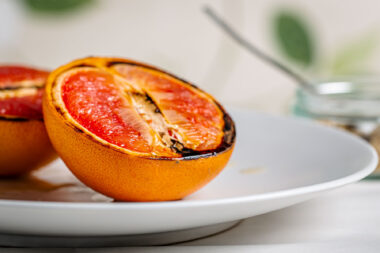 Grilled halves of orange on a white plate for a London food photography commission.