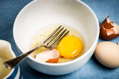 An egg in a white bowl with a fork for a commission for Holland Park School in London.