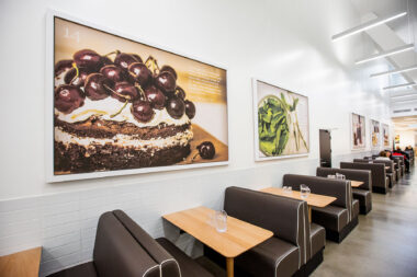 Interior of Holland Park School dining area showing commissioned food photography by Richard Boll.