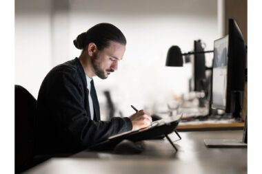 Lifestyle photography of a man working at a computer in a London design studio.