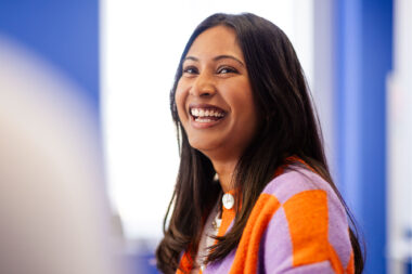 A woman laughing during a corporate meeting.