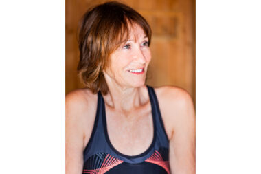 A smiling woman in a sauna.