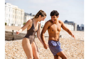 A laughing couple on a beach on a sunny day.