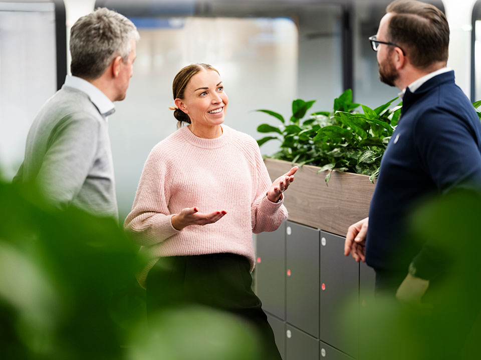 A woman discussing ideas with her colleagues in a corporate environment.