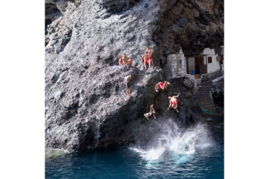 A photograph by Richard Boll of people jumping into the sea from a cliff titled I see the boys of summer.