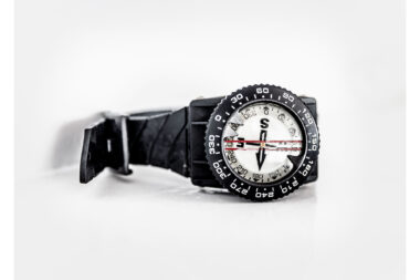 A close up macro photograph of a diving compass on the deck of a liveaboard diving boat. Richard Boll Photography based in London.