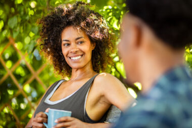 Two friends talking whilst taking a break from planting trees in a sunny allotment in London- people lifestyle photography by Richard Boll.