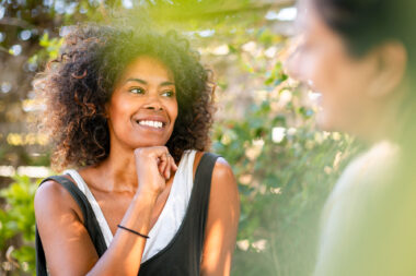 Friends talking whilst taking a break from gardening in a sunny community allotment- candid intimate lifestyle photography by Richard Boll, London.