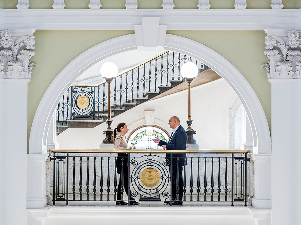 A man and a woman having a conversation in an office building photographed by corporate lifestyle photographer Richard Boll.
