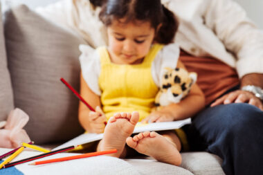A child sat drawing with her father in furniture lifestyle photography by Richard Boll.