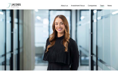 A web page showing a woman standing in a corridor photographed by corporate portrait photographer Richard Boll.