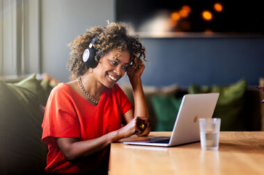 A woman wearing headphones in a cool interior space talking with someone on a laptop, photographed by lifestyle photographer Richard Boll.